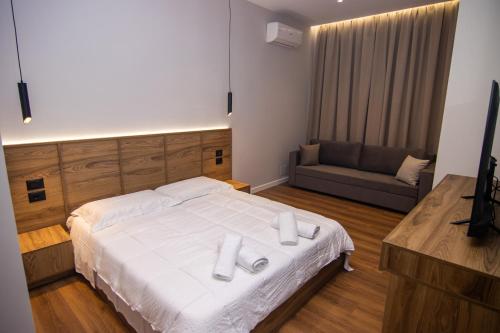 a bedroom with a large white bed and a couch at BB The Garden in Durrës
