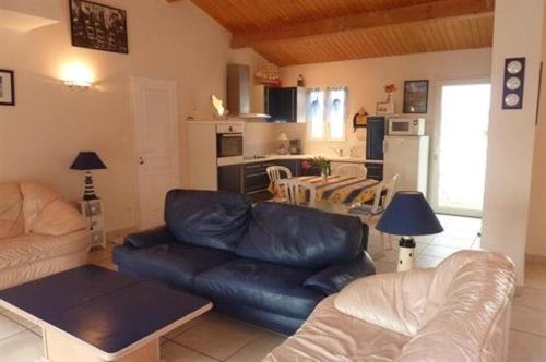 un salon avec un canapé en cuir et une cuisine dans l'établissement Maison 4 pièces 6 couchages Saint Pierre d'Oléron SPO000-691, à Saint-Pierre-dʼOléron