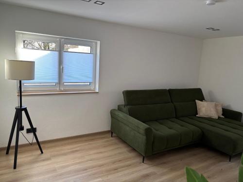 a living room with a green couch and two windows at Apartment in Miesenbach in Miesenbach