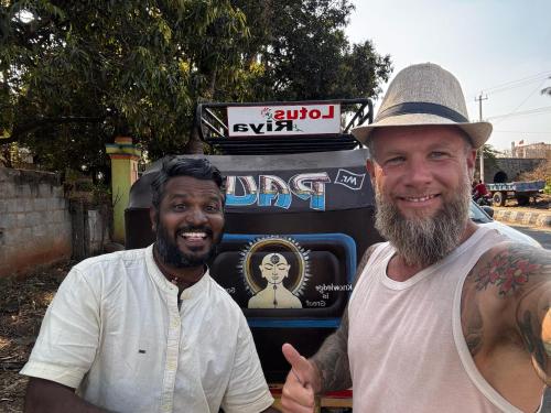 two men are standing in front of a truck at Budha Home Stay in Hampi