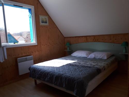 une chambre avec un lit dans une pièce avec une fenêtre dans l'établissement Gîte EAU'DER, à Giffaumont