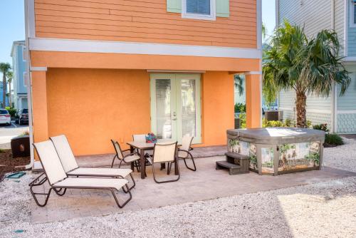 a patio with a table and chairs and a hot tub at Margaritaville Cottages Orlando with H2O Waterpark by Rentyl in Kissimmee