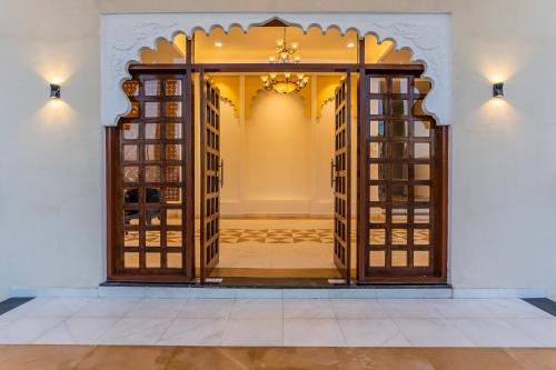 una puerta abierta a una habitación con una lámpara de araña en The Rosewalk Heritage Udaipur, en Udaipur