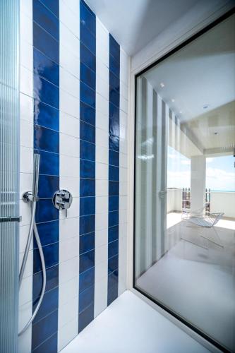 a bathroom with a shower with blue and white tiles at Murè Hotel Numana in Numana