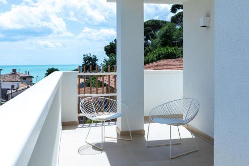 a balcony with two chairs and a view of the ocean at Murè Hotel Numana in Numana