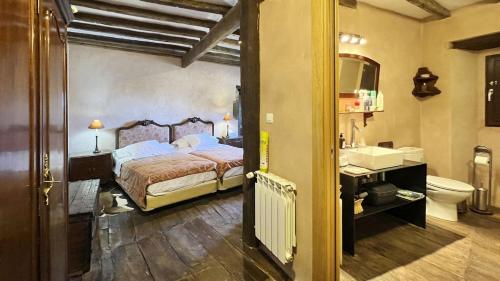 a bedroom with a bed and a sink and a toilet at La Casa de Celada in Celada de los Calderones