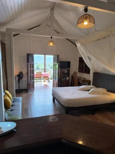 a bedroom with a bed and a living room at Studio moderne avec terrasse à Le Robert 60 m² in Le Robert