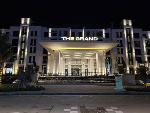 a large white building with a sign that reads the grand at SEA BREEZE LIGHTHOUSE in Baku