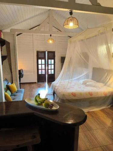 a bedroom with a bed with a tray of fruit on a table at Studio moderne avec terrasse à Le Robert 60 m² in Le Robert