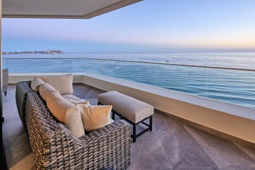 a balcony with a couch and a chair and the ocean at LUXURY NEW OCEANFRONT CONDO 5BR Sleeps 12 in Puerto Peñasco
