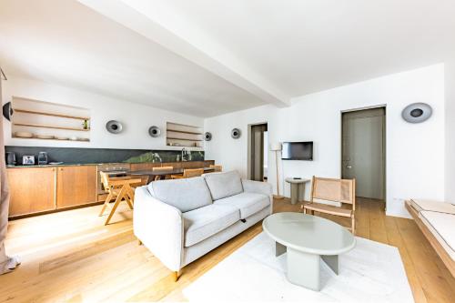 un salon avec un canapé blanc et une table dans l'établissement Cosy Apartment 1BR 4P Jardin du Luxembourg, à Paris
