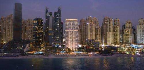 a view of a city at night with buildings at La Vie in JBR! Private Beach! Excellent Apartments! in Dubai