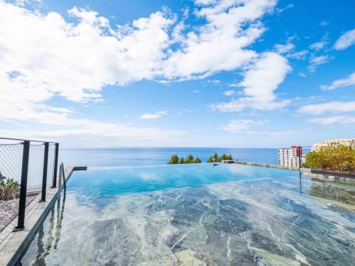 a swimming pool with a view of the ocean at Savoy Monumentalis your home in Madeira Island in Funchal