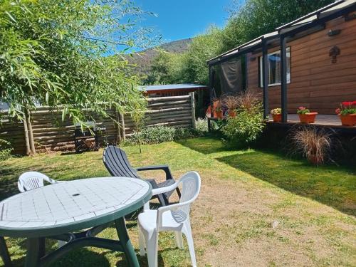 a table and chairs in the yard of a cabin at El Vagon in San Martín de los Andes