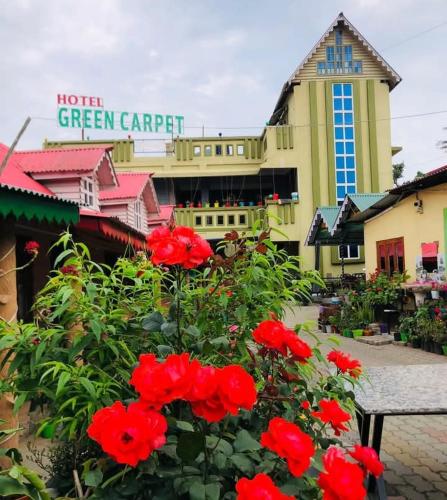 SuryodayaにあるHotel Green Carpetの建物前の赤花群