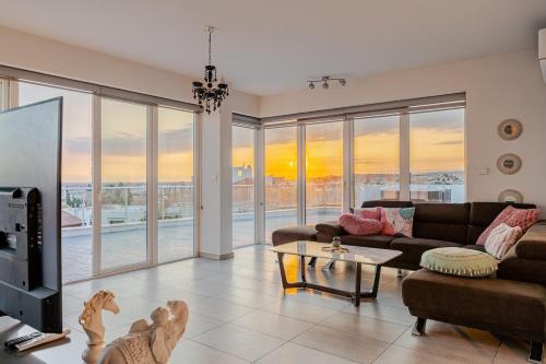 a living room with a couch and a table at Penthouse with outdoor hottub in Limassol