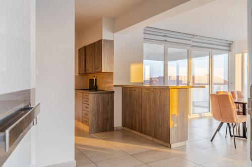 a kitchen with wooden cabinets and a table and chairs at Penthouse with outdoor hottub in Limassol