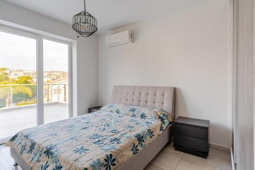 a bedroom with a bed and a large window at Penthouse with outdoor hottub in Limassol