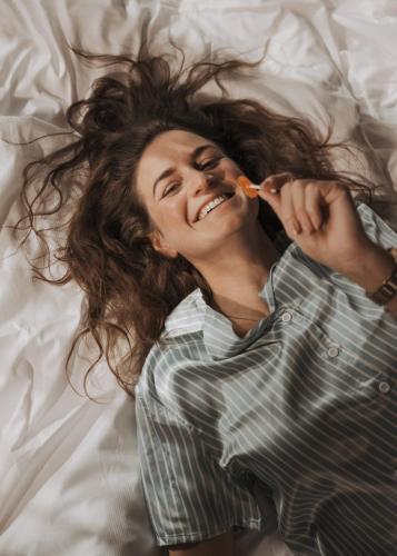 a woman laying on a bed brushing her teeth at GOING TRIPLE A apartments WEST in Going