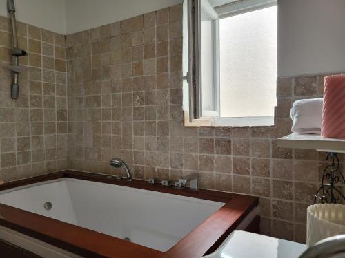 une baignoire dans une salle de bain avec une fenêtre dans l'établissement Chambre avec parties communes en bord de mer, à Port-la-Nouvelle