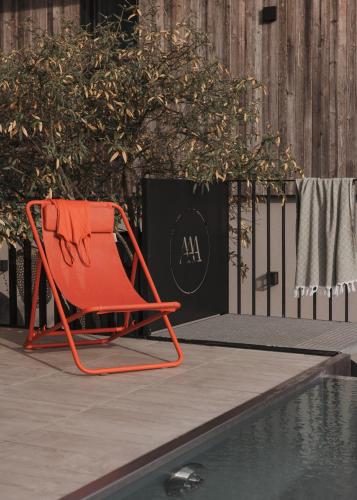 a orange chair sitting next to a swimming pool at GOING TRIPLE A apartments WEST in Going
