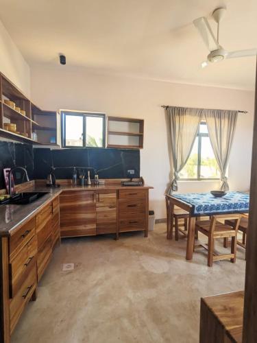 a large kitchen with wooden cabinets and a table at Alcyone Residence - Ocean View Villa in Muyuni