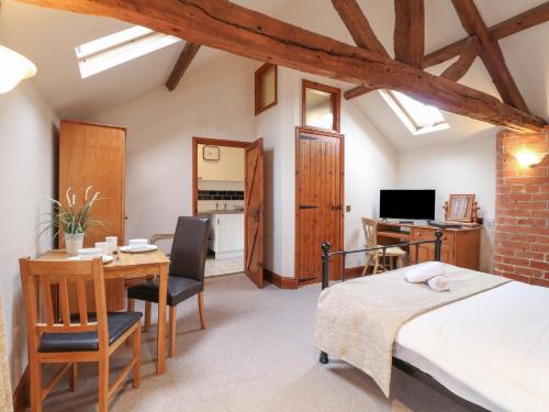 a bedroom with a bed and a desk and a table at Hayloft in Derby