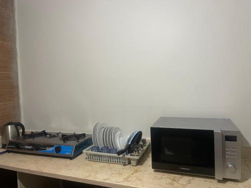 a kitchen counter with a microwave and a stove at Diyar Pyramids Inn in Cairo