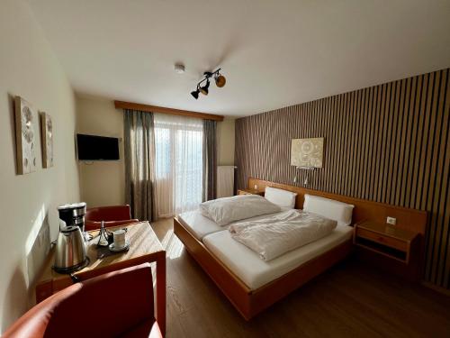 a bedroom with a bed and a table and a window at Aparthotel Hochfeld in Schönau am Königssee