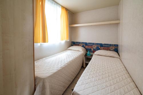 Letto o letti in una camera di Villaggio Camping Punta Lunga