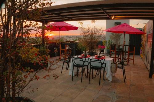 a patio with tables and chairs and red umbrellas at Elena de Cobre, Leon, a Member of Design Hotels in León