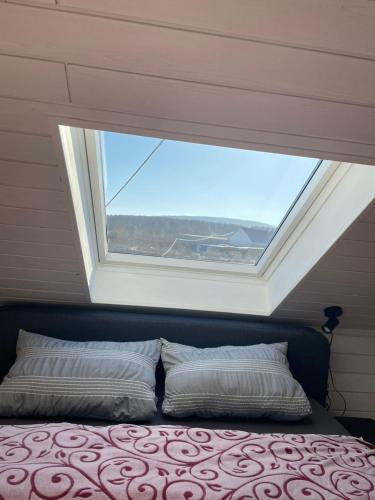 a bed in a room with a large window at Ferienwohnung IDYLL in Niederweiler