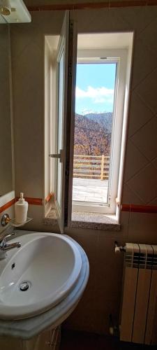 a bathroom with a sink and a window with a view at Casa das Oliveiras - Manteigas in Manteigas