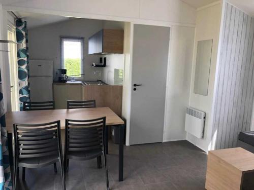 a kitchen and dining room with a table and chairs at Camping 3 étoiles - Piscine - ccaihff in Saint-Georges-de-Didonne