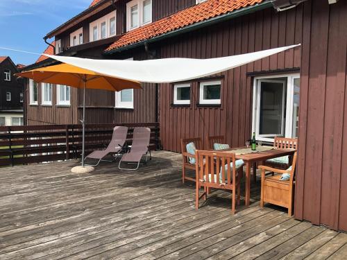 un patio con una mesa y una sombrilla en una terraza en Harzer Weitblick, en Braunlage