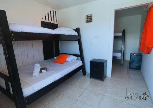 a bedroom with two bunk beds with an orange pillow at Hotel colombia in Tolú