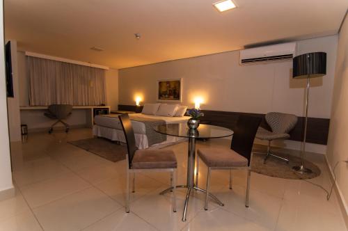 a hotel room with a bed and a table and chairs at Oscar Hotel Executive in Porto Velho