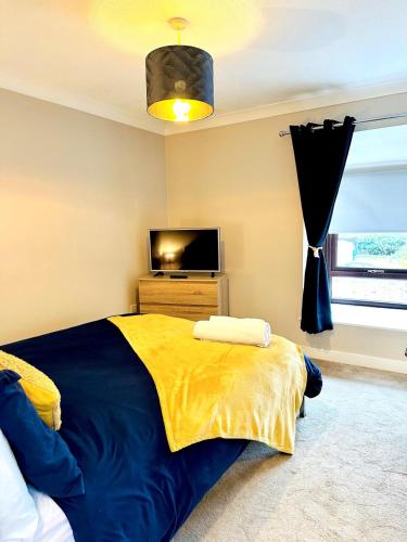 a bedroom with a bed and a tv in it at Modern House Soham Town Centre in Soham
