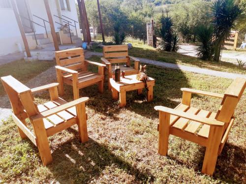 a group of wooden benches sitting in the grass at Altos del Peñón Cabañas in Casa Grande