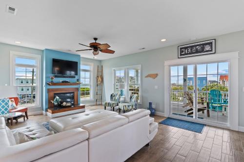 a living room with white furniture and a fireplace at Hakuna Matata by Sea Scape Properties in North Topsail Beach