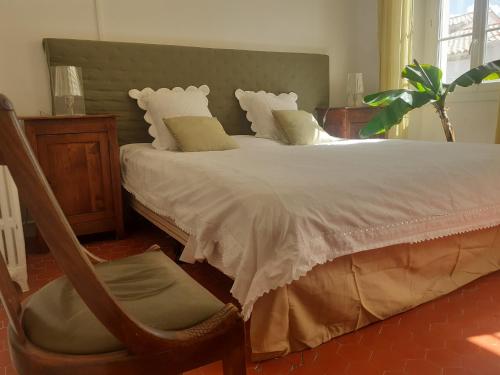 - une chambre avec un lit blanc, une chaise et une fenêtre dans l'établissement Chambre avec parties communes ambiance méditerranée, à Port-la-Nouvelle