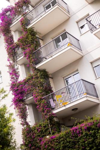 a building with purple flowers on the balconies at Residence Sabrina in Ceriale