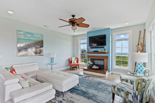 a living room with a white couch and a tv at Hakuna Matata by Sea Scape Properties in North Topsail Beach