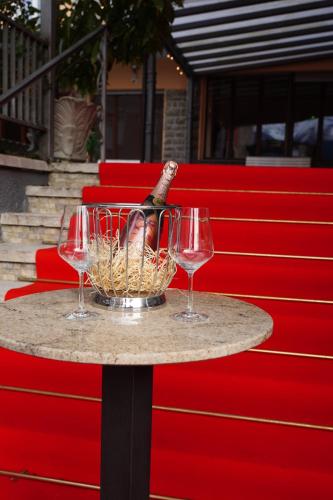 a table with two wine glasses and a bottle on it at Hotel Garden in Levico Terme