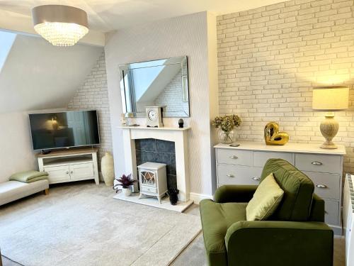 a living room with a couch and a tv and a fireplace at Willesden, Apartment 2, A beautifully furnished and spacious apartment located in the heart of Llandudno in Llandudno