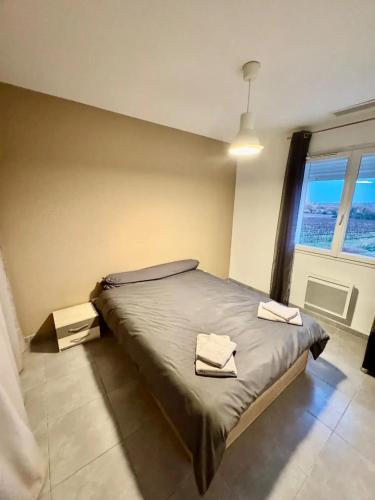 une chambre avec un lit avec deux serviettes dessus dans l'établissement Maison lumineuse à Restinclières avec jardin et terrasse, à Restinclières