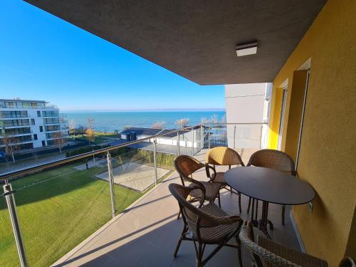 a balcony with a table and chairs and a view of the ocean at AF Panorama Lux in Siófok
