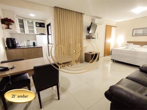 a living room with a table and a bed at Coruja Imob - Flat Crystal Place in Goiânia