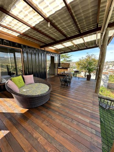 a covered deck with a couch and a table at Chalé Contêiner com Vista para Serra da Canastra in São Roque de Minas