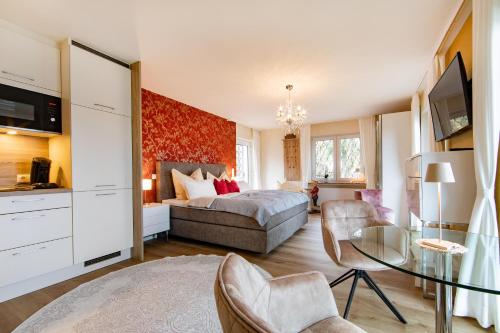 Una sala de estar con una cama y una mesa de cristal. en Haus Marianne am Maar, en Schalkenmehren